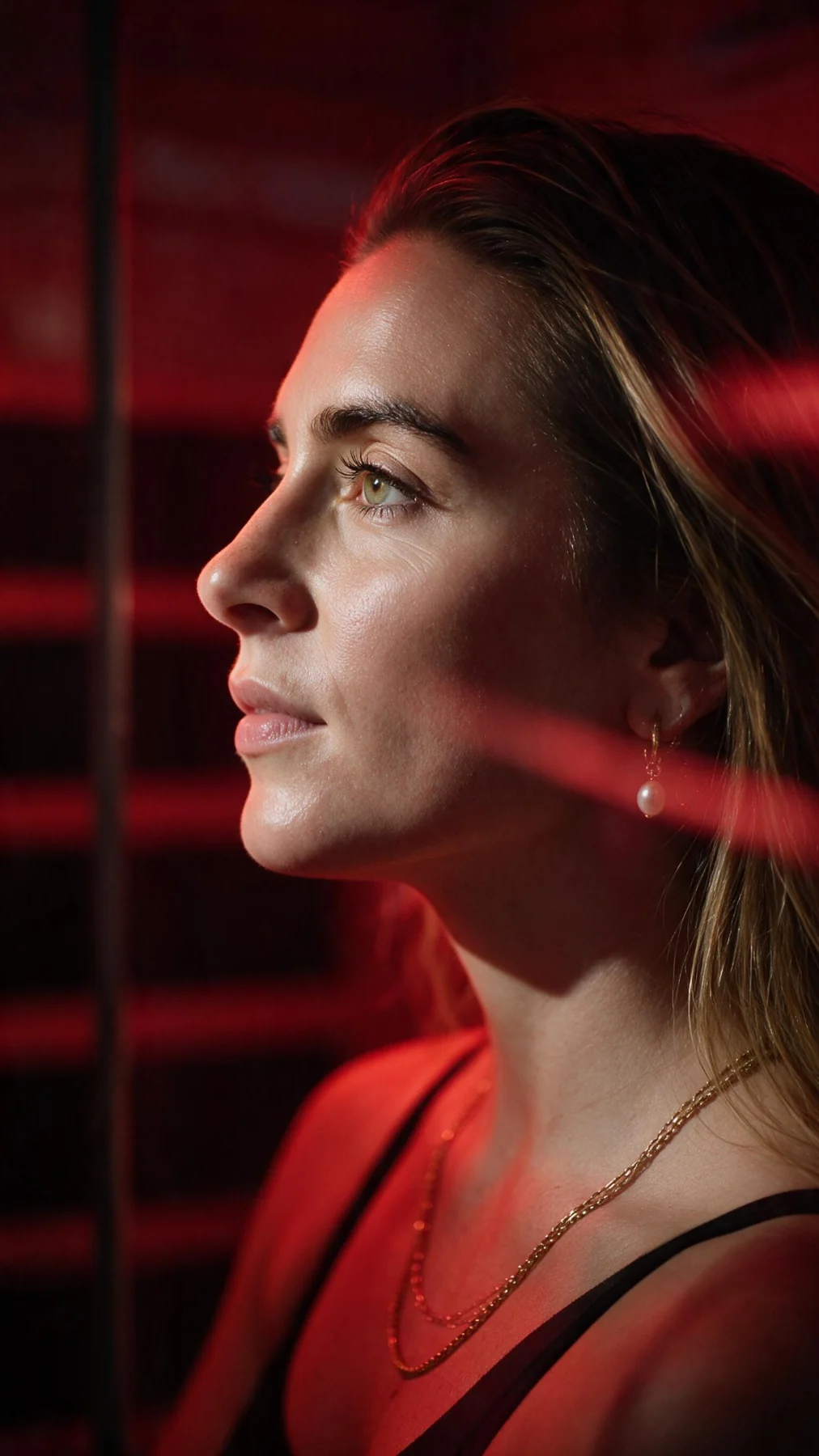 Editorial red-lit profile portrait of Ashley