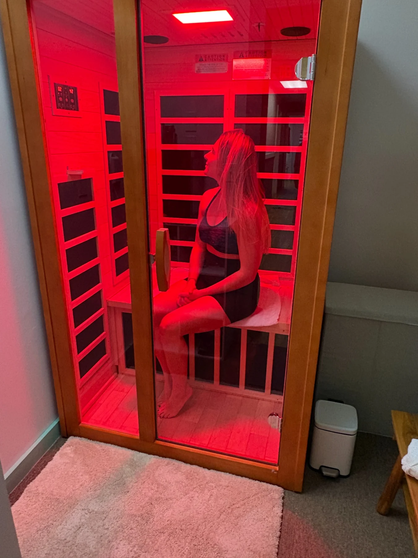 Ashley inside red-lit sauna
